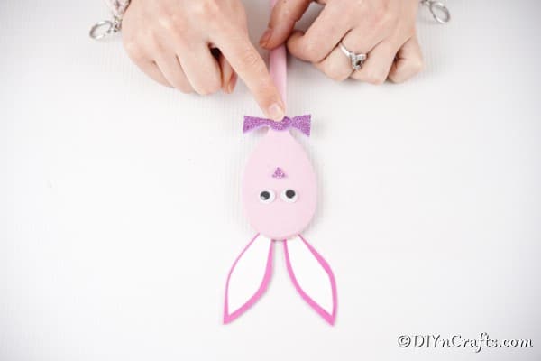 Gluing bow to pink spoon