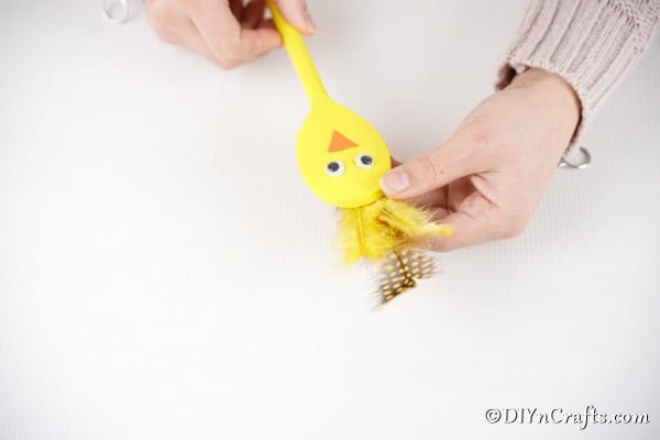 Adding feathers to yellow spoon