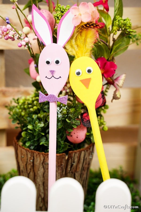Bunny and chick spoons against wooden stump