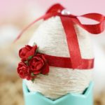 Side view of a yarn and ribbon covered Easter egg