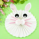 Easter bunny craft on green table by flowers