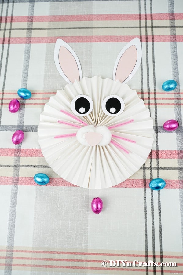 Paper bunny on striped tablecloth