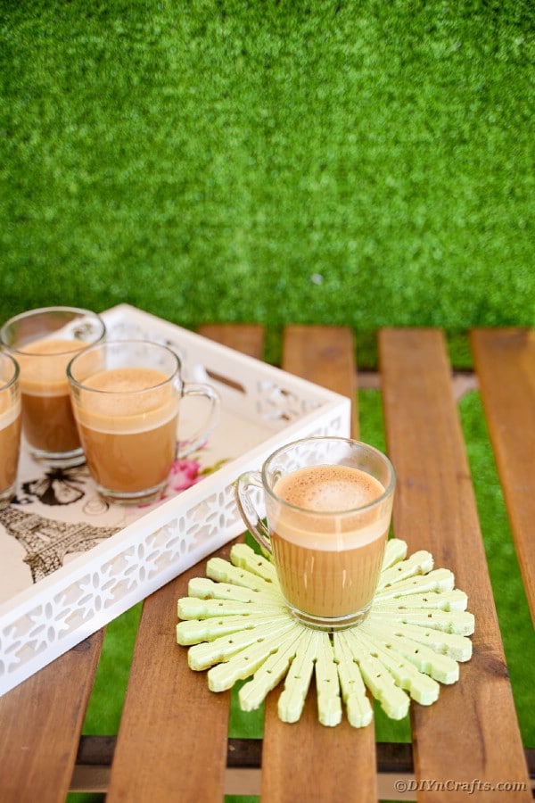 Serving tray on wooden bench with coffee cups and coaster