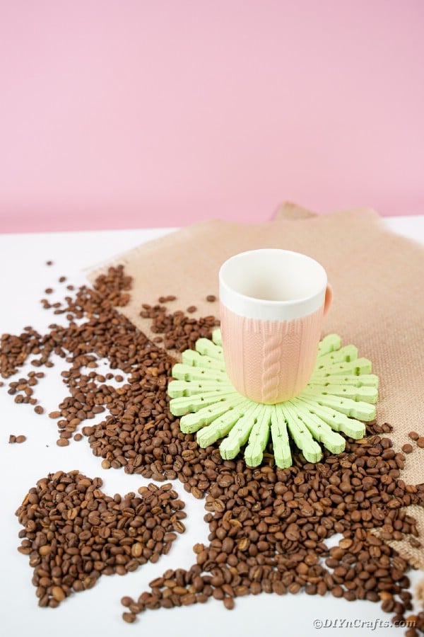 Coaster with coffee cup on table with coffee beans