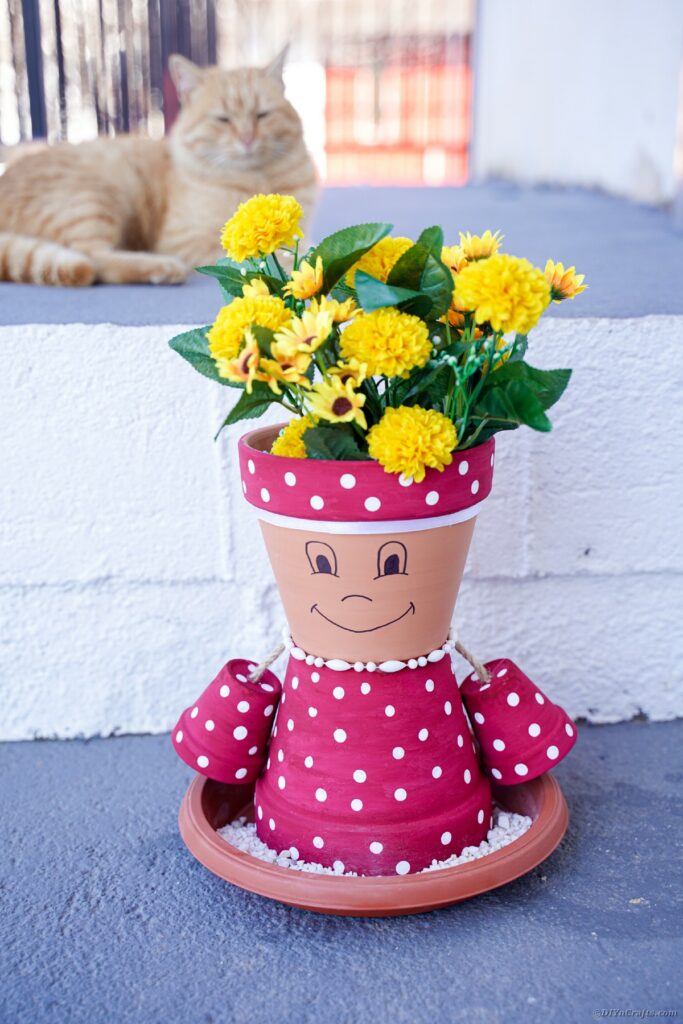 Flower pot girl by brick outside