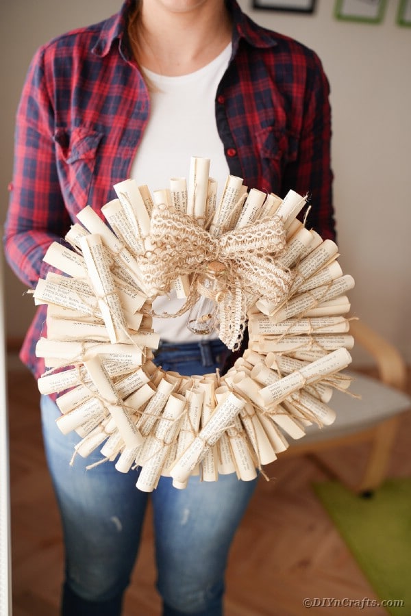 Woman holding an old book page wreath