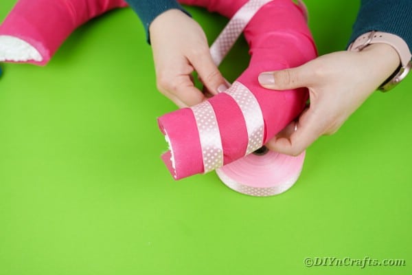 Wrapping ribbon around a pink basket handle