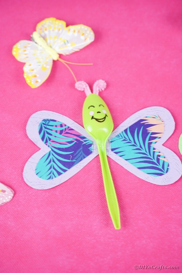 Green spoon on pink paper