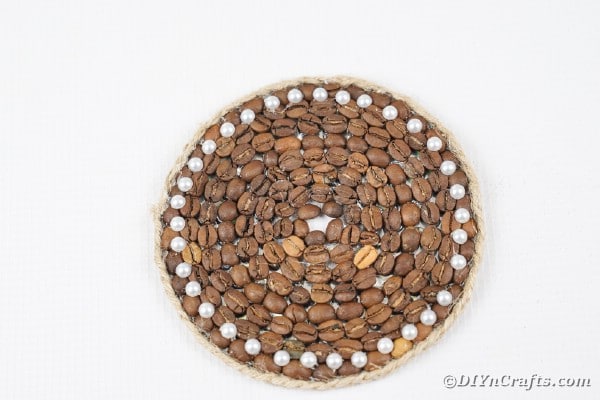 Coffee bean coaster on white surface