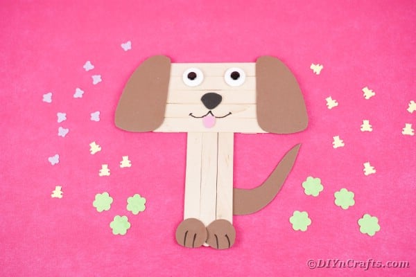 Popsicle stick puppy on pink surface