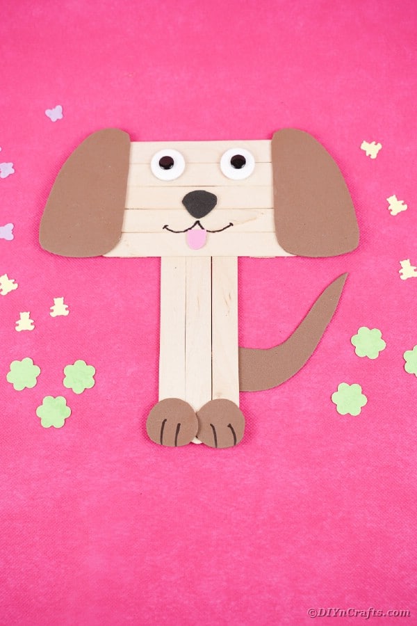 Popsicle stick puppy on pink surface