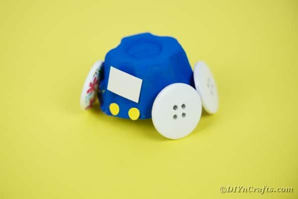 Blue egg carton car on yellow surface