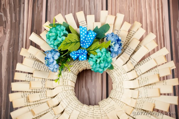 Old book page wreath on wooden wall