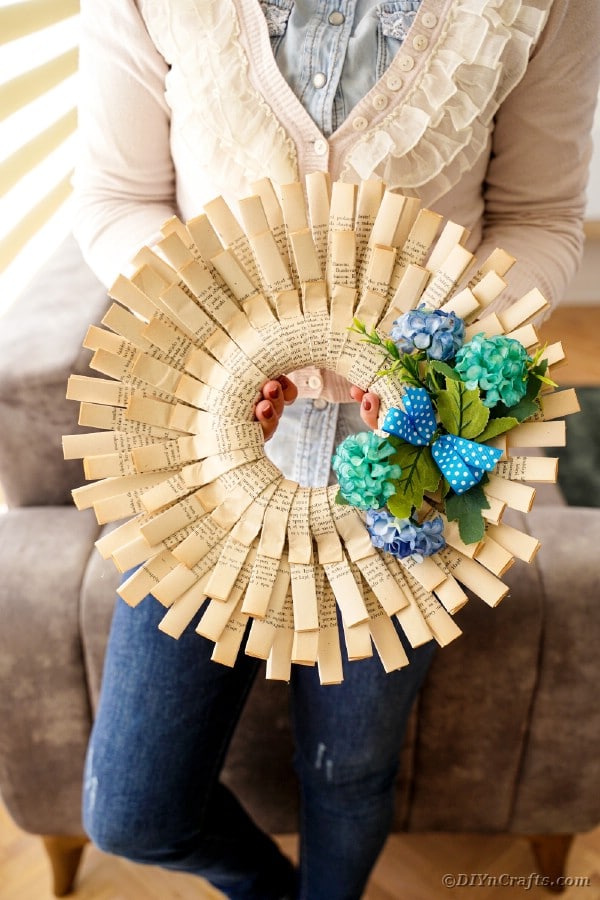 Woman holding folded paper wreath