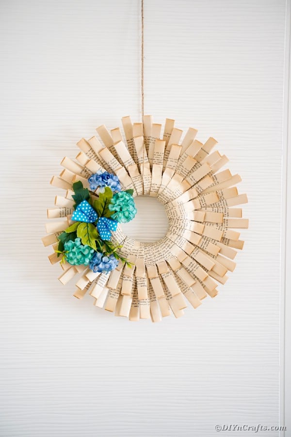 Paper wreath with blue flowers on white wall