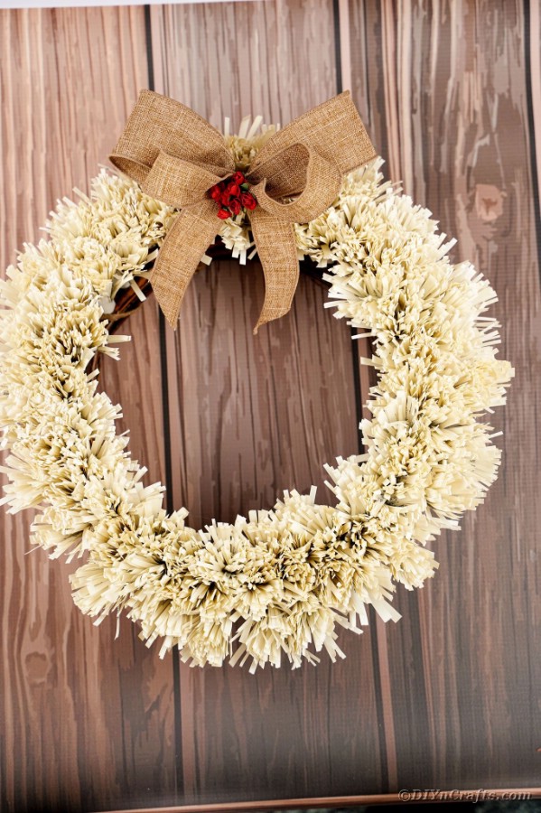 Paper fringed wreath on wooden surface