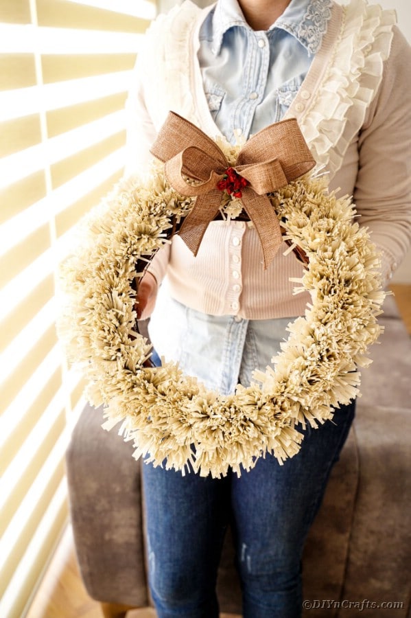 Woman holding paper fringe wreath