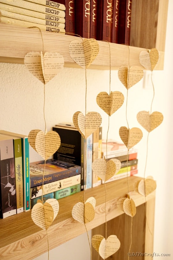 Herzgirlande, die durch Bücherregal hängt