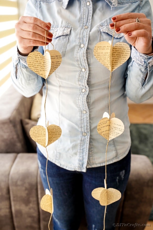 Woman holding a book page heart garland