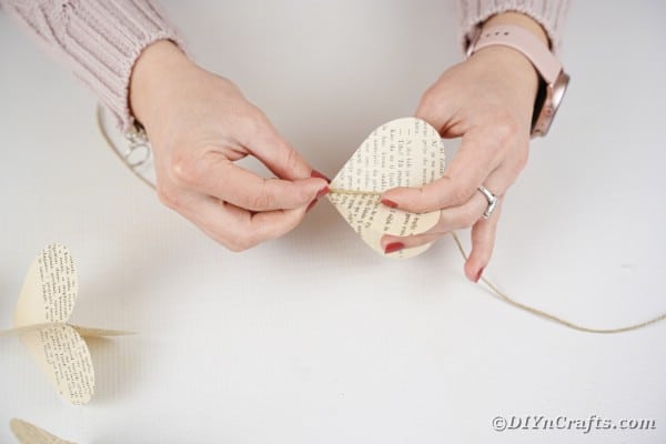 Gluing paper hearts to twine