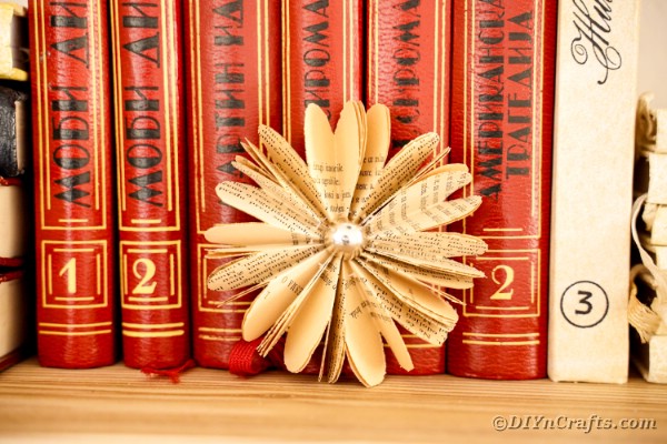 Paper flower in front of stack of books