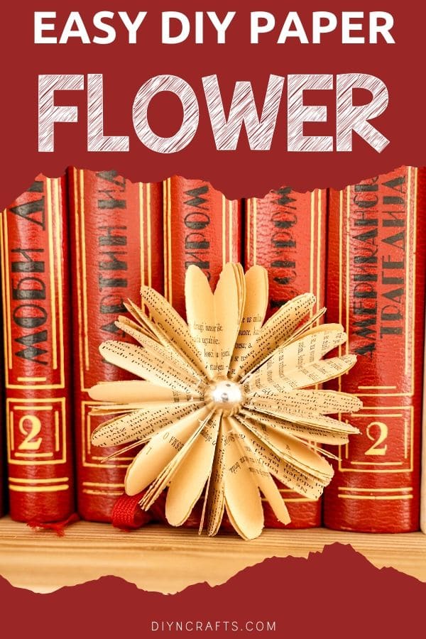 Paper flower in front of stack of books