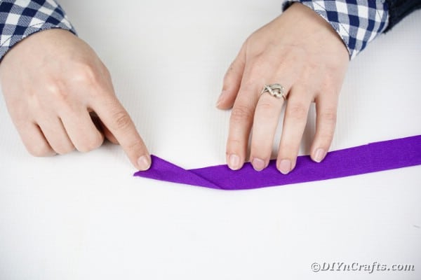 Rolling a purple tissue paper rose