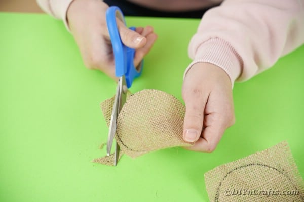 Cutting a circle of burlap out