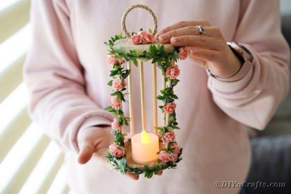 Woman holding birdcage candle holder