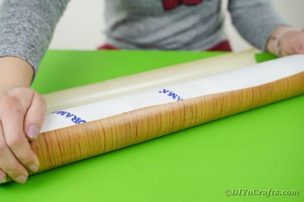 Covering cardboard tube in paper