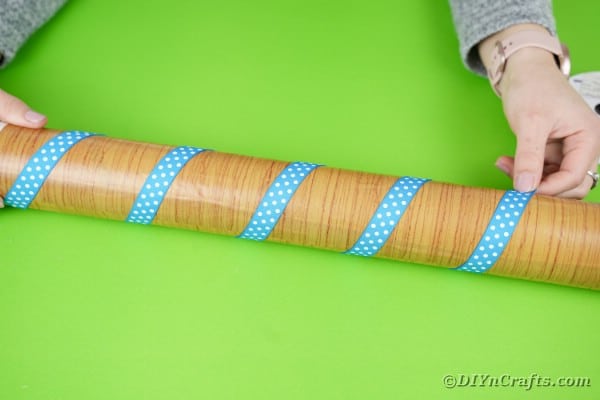Wrapping cardboard tube in ribbon