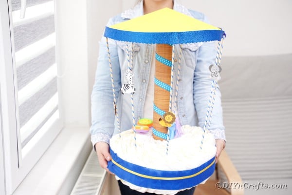 Woman holding carousel diaper cake