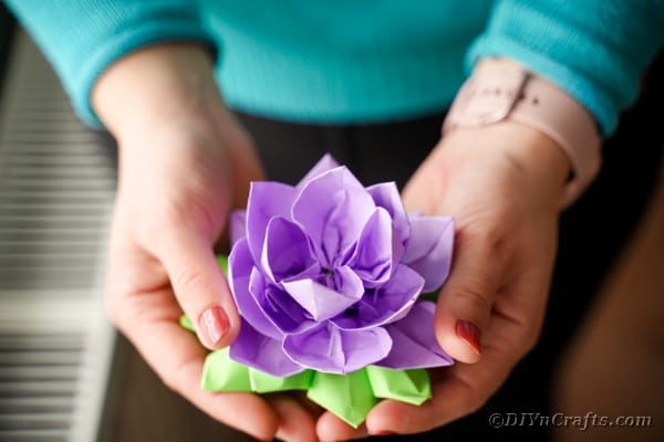 Femme tenant un lotus en papier