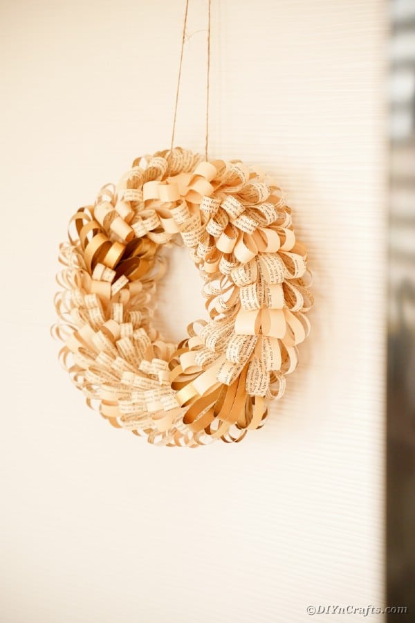 Old book page wreath on cream wall