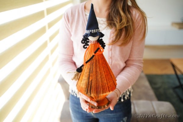Woman holding paper witch