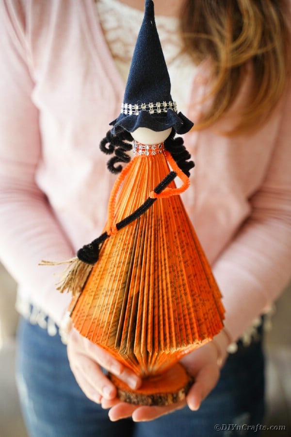 Woman holding paper witch