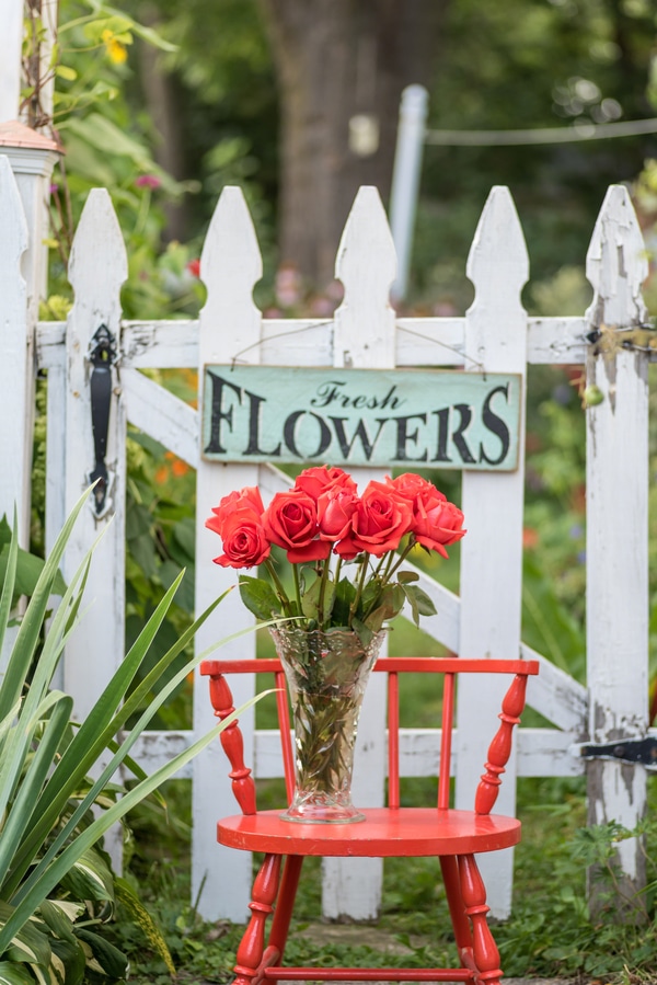 Hanging flower sign by red chair
