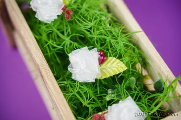 Ribbon flowers in box with fake grass