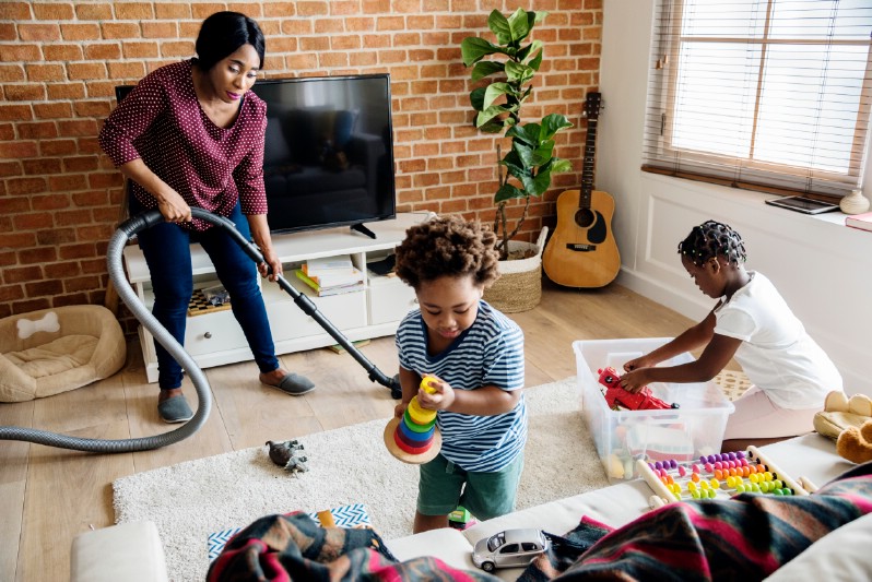 Family vacuuming the house together.
