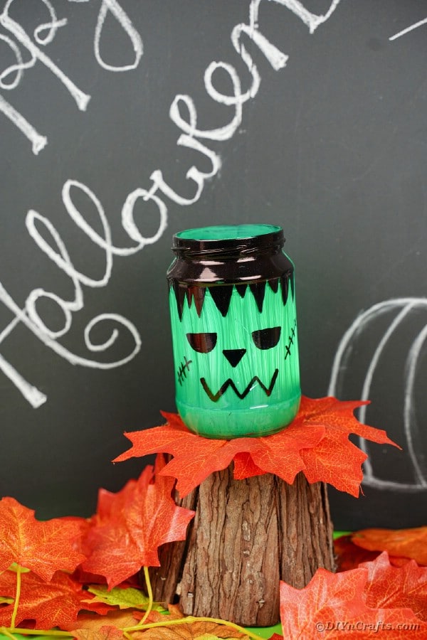 Mason jar lantern lit in front of chalkboard