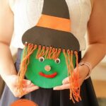 Woman holding paper plate witch face