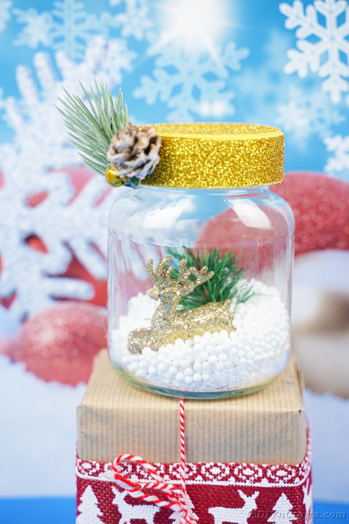 snow globe with yellow cap on top of gift with blue background