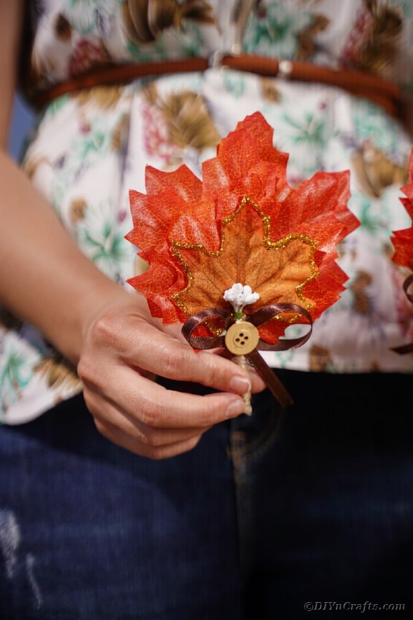Woman holding fall leaf boutonniere