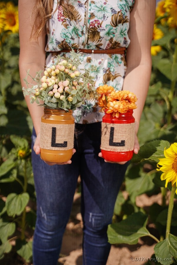 Woman holding fall letter jars