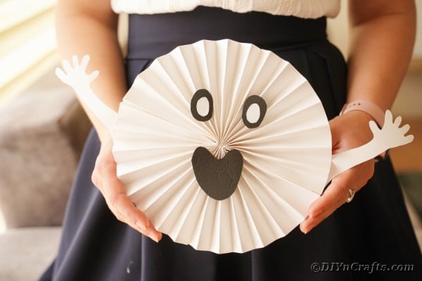 Woman holding paper ghost decoration