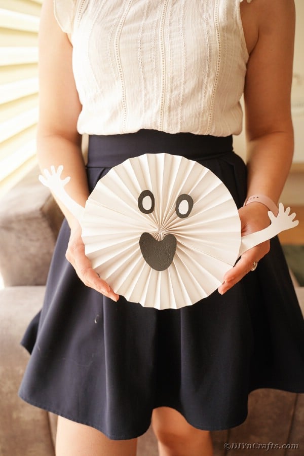 Woman holding paper ghost decoration