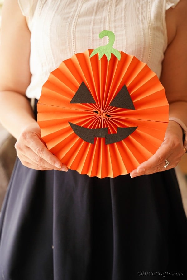 Woman holding paper fan pumpkin