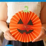 Woman holding paper fan pumpkin