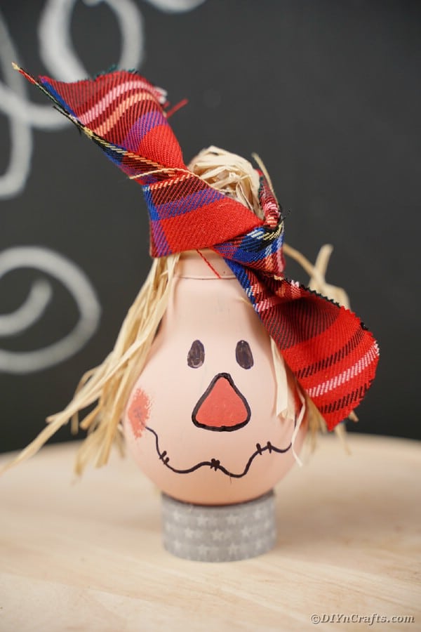 Lightbulb scarecrow on table by chalkboard