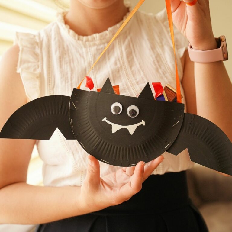 Woman holding a paper plate bat filled with candy